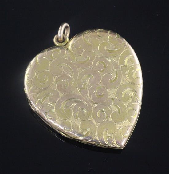 An engraved yellow metal heart shaped pendant locket, 47mm.